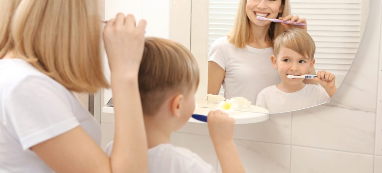 image of mum and son brushing their teeth while looking in the mirror image of mum and son brushing their teeth while looking in the mirror