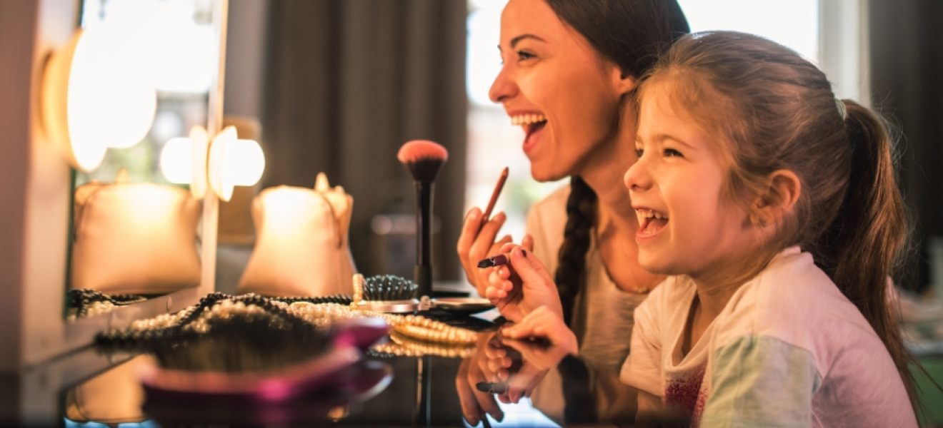 picture of a happy mum and daughter experimenting with makeup