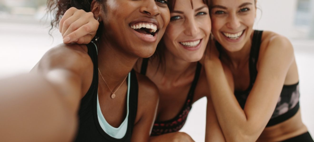 picture of 3 happy and healthy women in workout clothes