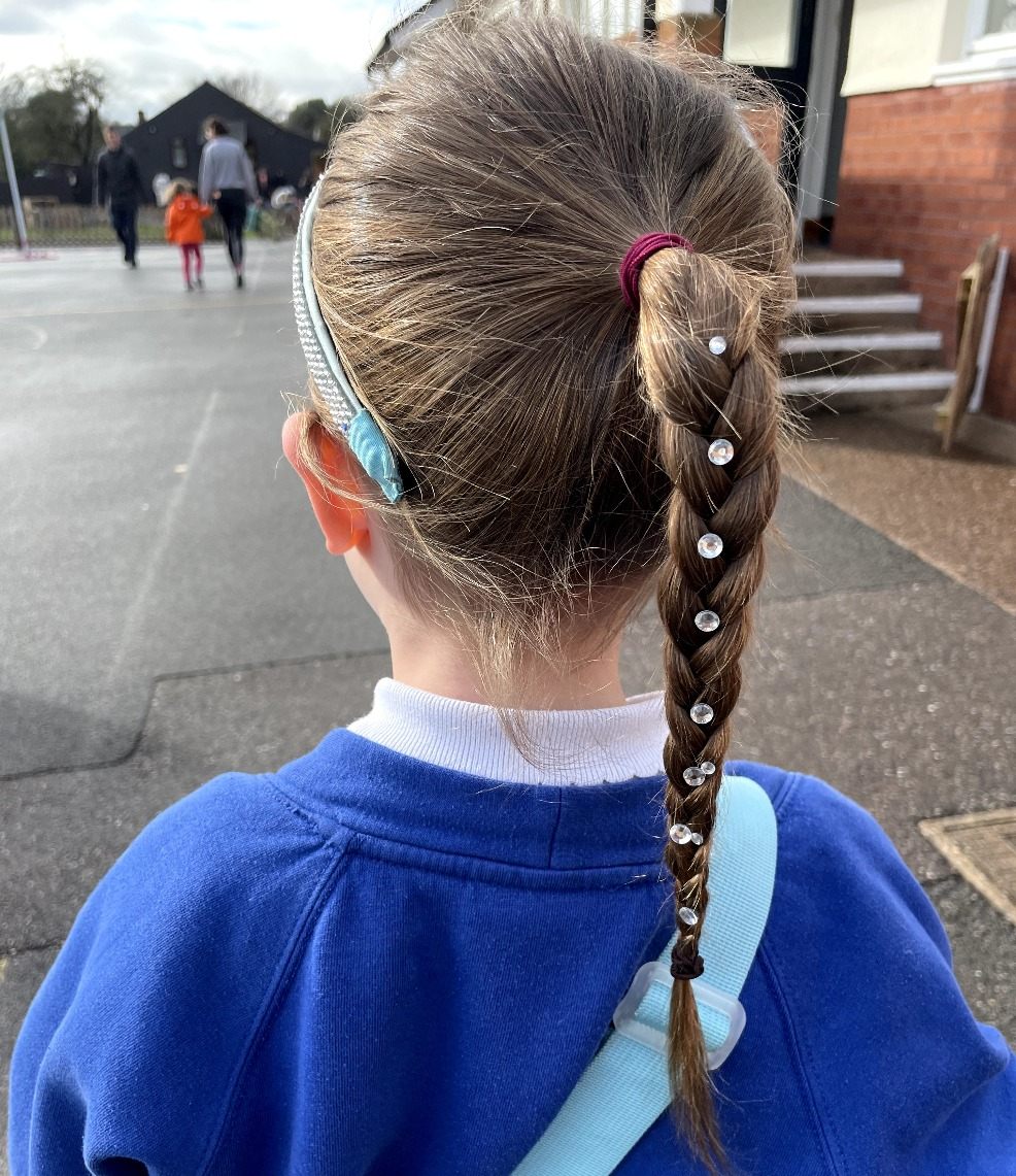 picture of a child with hair gems in her plaited hair