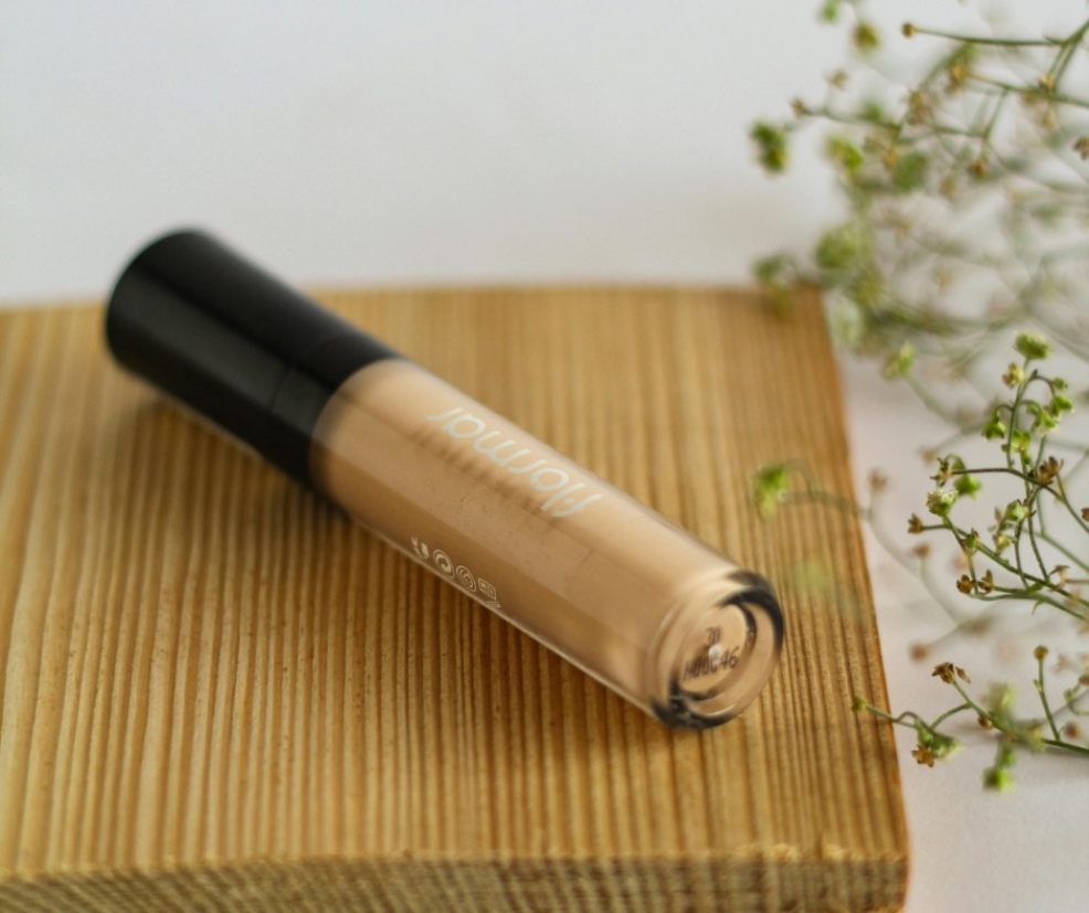 picture of a tube of concealer on a piece of bamboo
