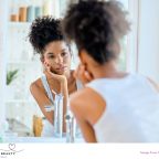 picture of a teenager doing a skincare routine looking in a mirror